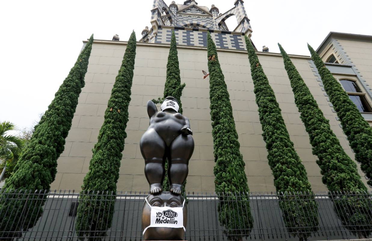 En la Plaza Botero, en inmediaciones del Museo de Antioquia, los rostros de las tradicionales figuras del maestro Fernando Botero fueron cubiertos con tapabocas. FOTO JAIME PÉREZ