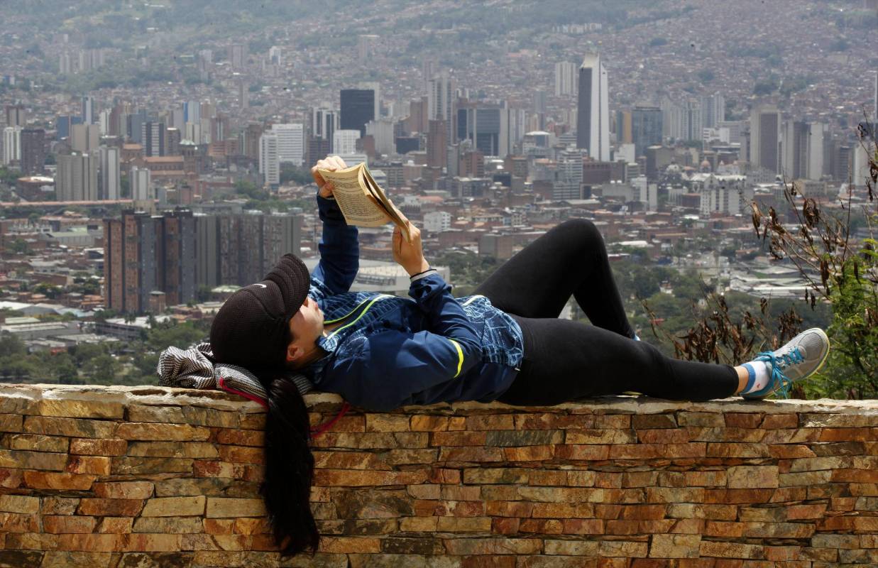 En medio de la agitada rutina de la ciudad, lectores espontáneos aprovechan un momento de calma para leer un buen libro. Foto: Manuel Saldarriaga.