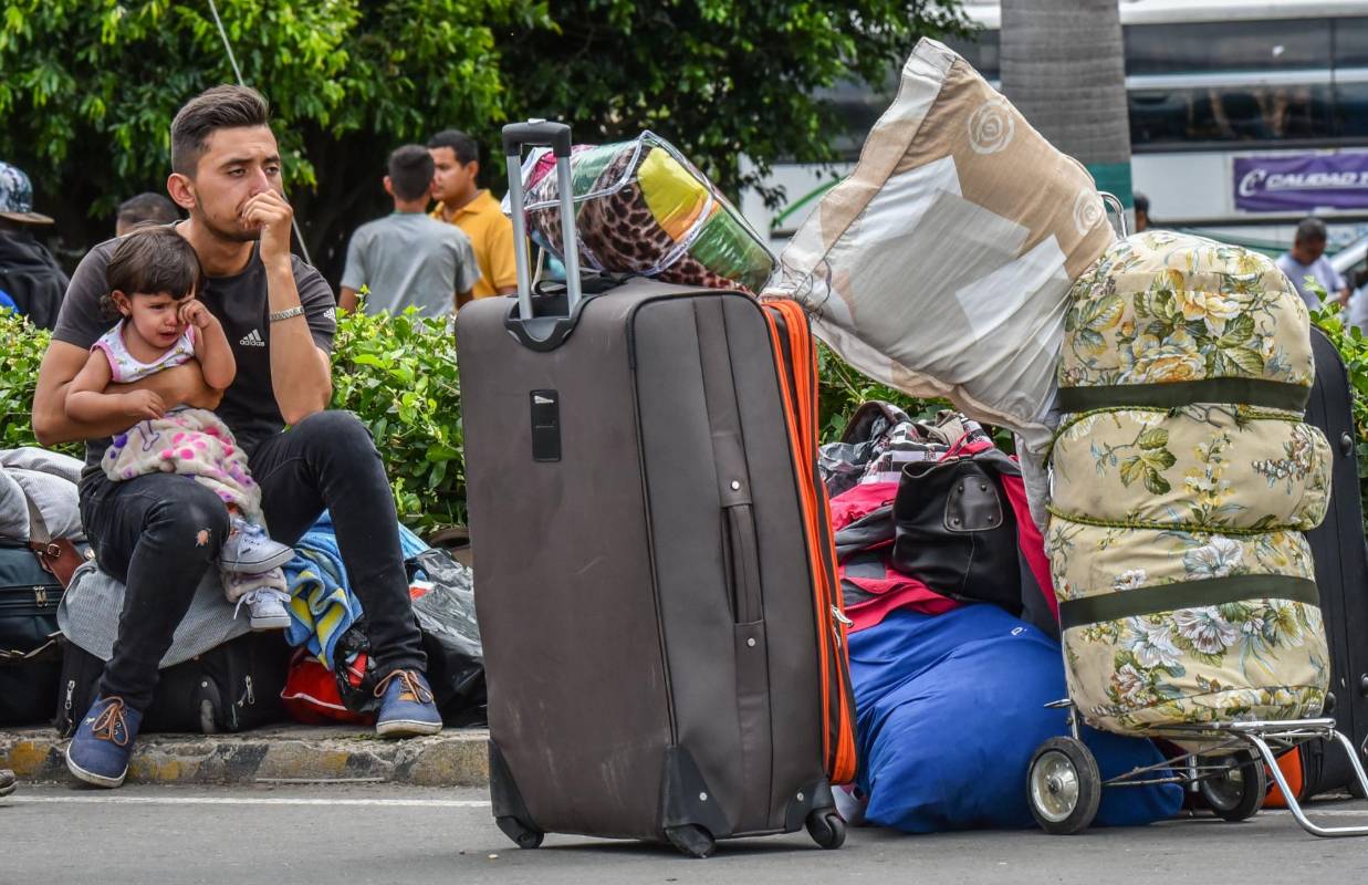 Niño y padre esperan desconsolados una ayuda en Cúcuta. Según fuentes oficiales, unos 25.000 venezolanos cruzan a Colombia y regresan a su país diariamente. FOTO AFP