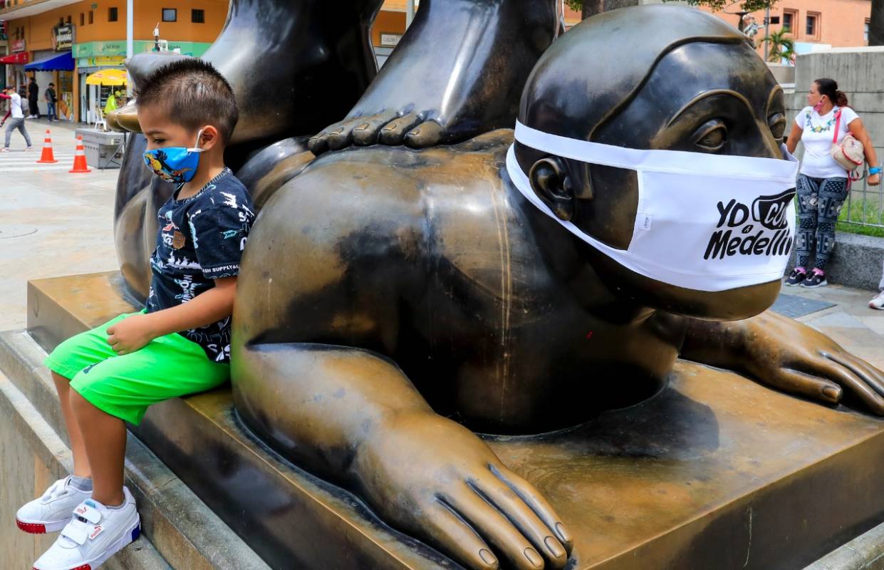En la Plaza Botero, en inmediaciones del Museo de Antioquia, los rostros de las tradicionales figuras del maestro Fernando Botero fueron cubiertos con tapabocas. FOTO JAIME PÉREZ