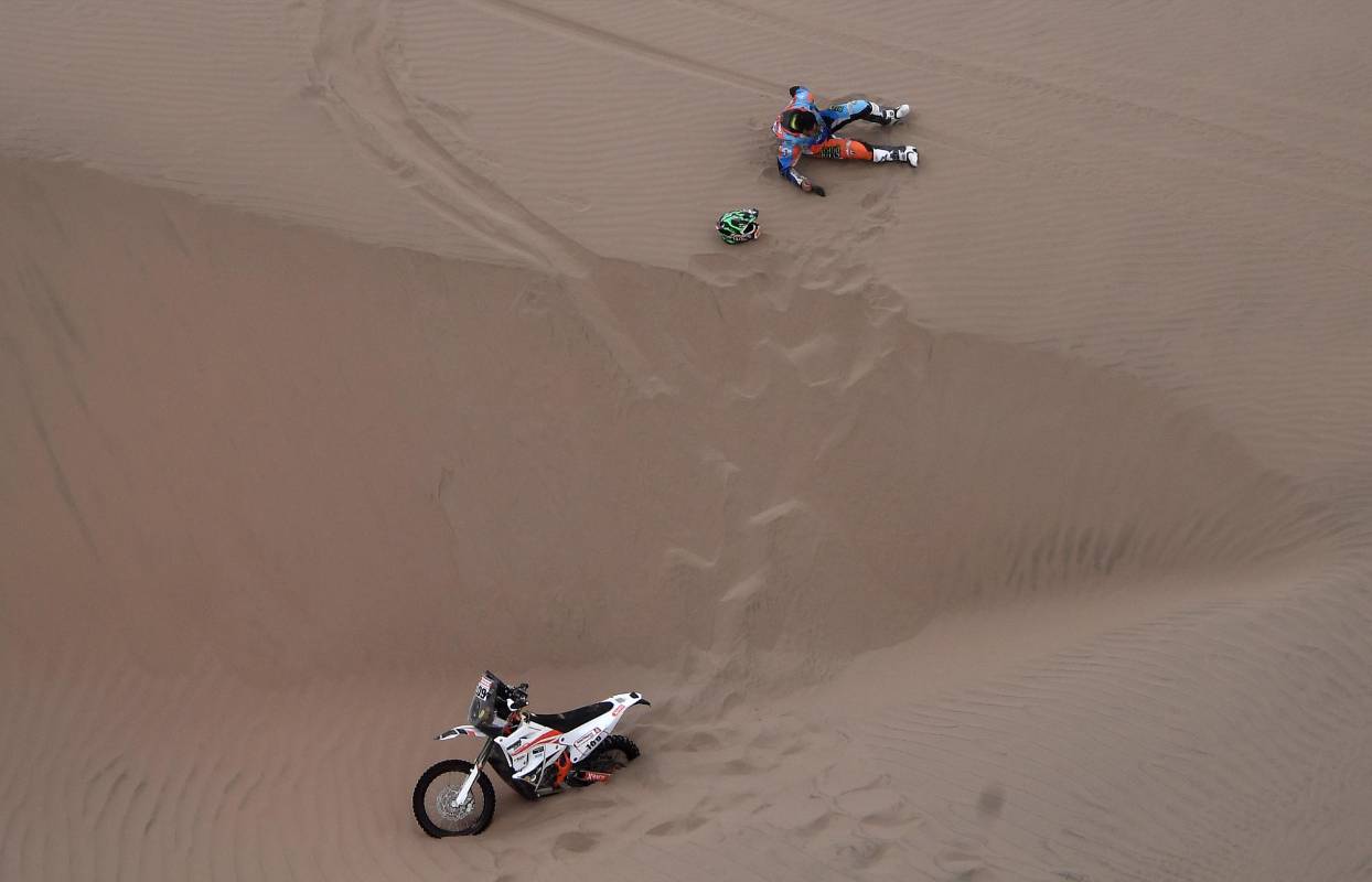 El motociclista brasileño Marcos Colvero se encuentra en la arena después de estrellarse durante la Etapa 3 del Dakar 2019 entre San Juan de Marcona y Arequipa, Perú. Foto: AFP