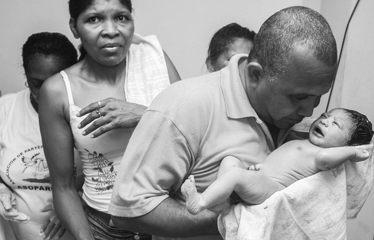 Liliana Moreno se agarró como pudo de las mujeres de la familia que la acompañaron en el proceso del parto. Feliciana Hurtado y Rosmilda Quiñonez fuerón las parteras que con mucho esfuerzo y cuidado asistieron el nacimiento del pequeño Jorge. El padre cortó el cordón úmbilical y luego abrazó su hijo. Foto: Manuel Saldarriaga Quntero