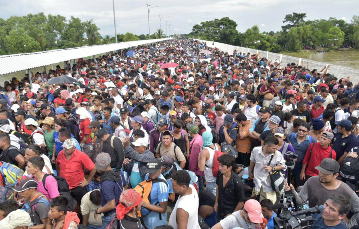 Miles de migrantes hondureños, que salieron en caravana de su país con destino a Estados Unidos, viven una tensa espera en el puente fronterizo entre México y Guatemala.