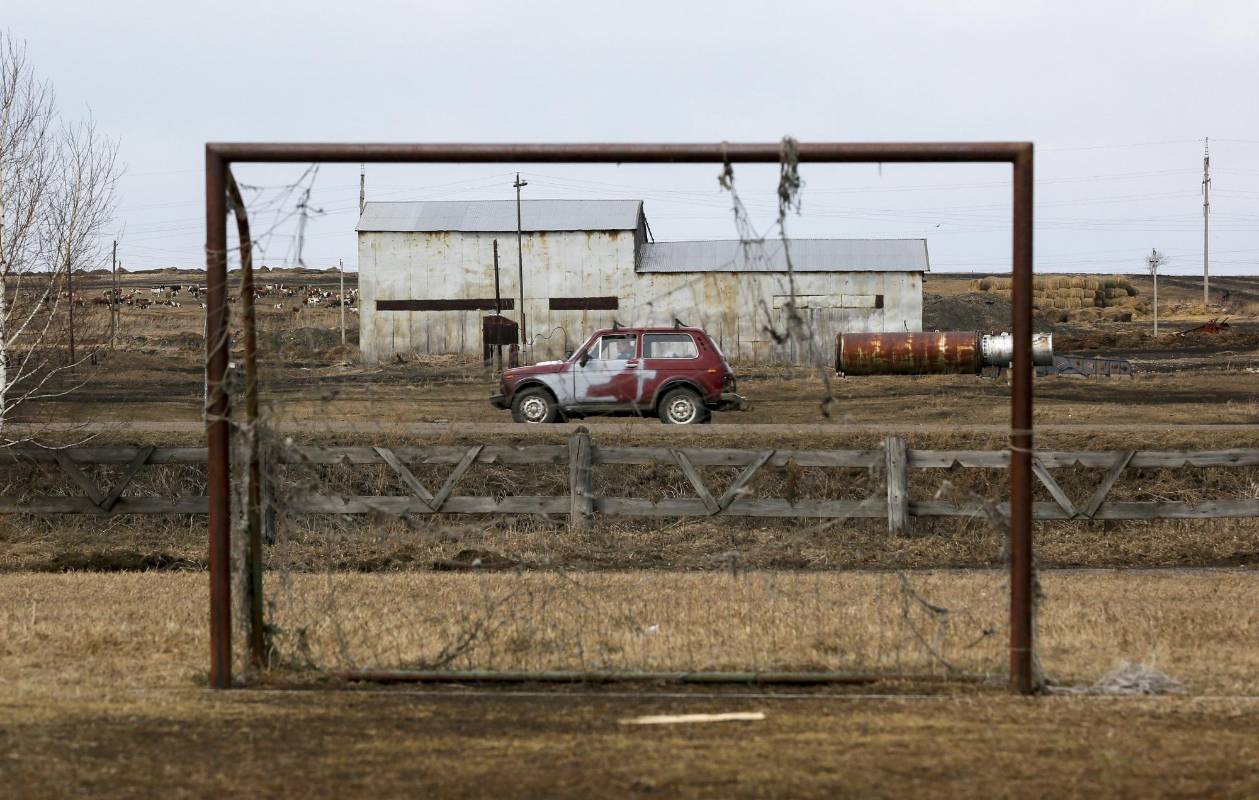 Un automóvil se ve a través de un arco mientras conduce a lo largo de una carretera en la aldea siberiana de Tyulkovo, región de Krasnoyarsk, Rusia. Foto: REUTERS / Ilya Naymushin
