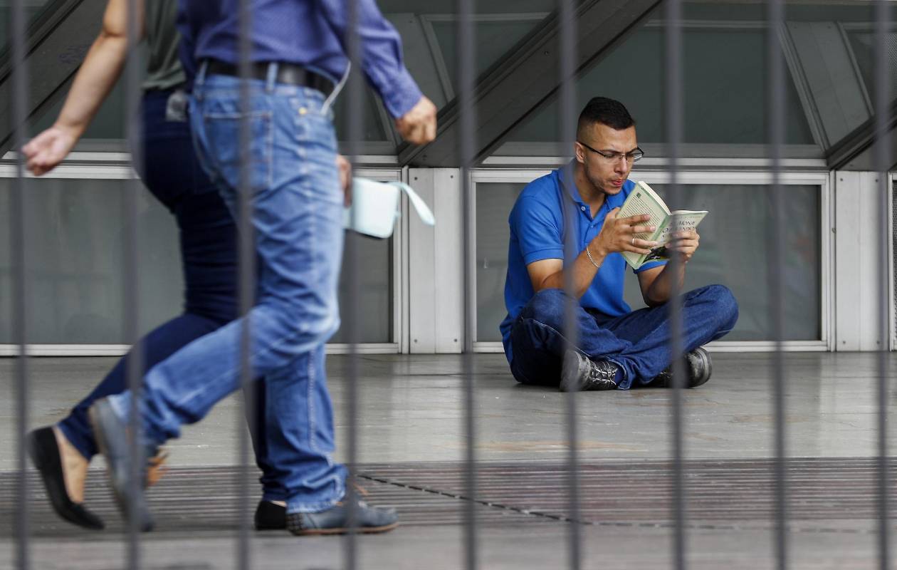 En medio de la agitada rutina de la ciudad, lectores espontáneos aprovechan un momento de calma para leer un buen libro. Foto: Manuel Saldarriaga.