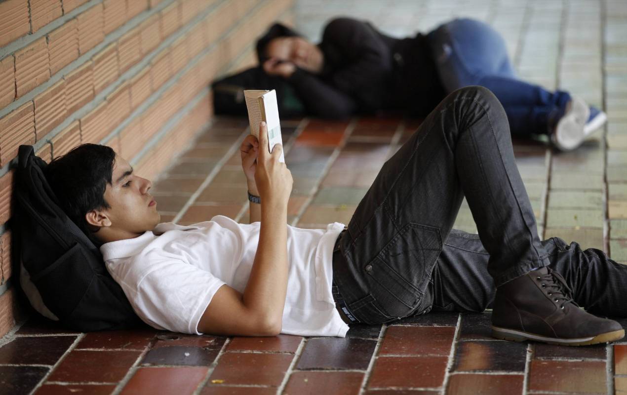 En medio de la agitada rutina de la ciudad, lectores espontáneos aprovechan un momento de calma para leer un buen libro. Foto: Manuel Saldarriaga.