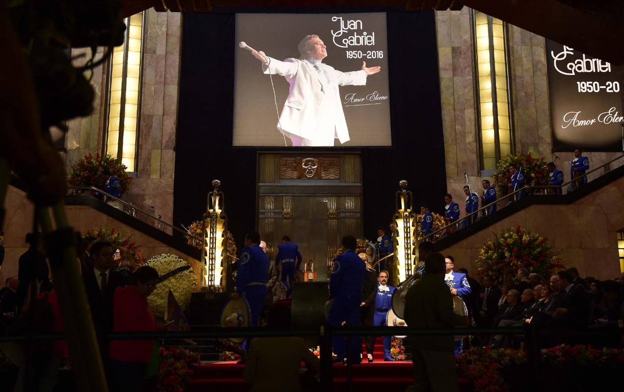 Detrás de las cenizas hay coronas de flores de diversas personalidades. La de rosas blancas de la izquierda fue enviada por el cantante Luis Miguel. FOTO AFP