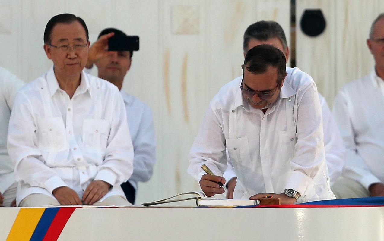 Rodrigo Londoño, comandante de las Farc, estampó su firma en los acuerdos con el balígrafo, que le regaló el Presidente Santos. FOTO AP