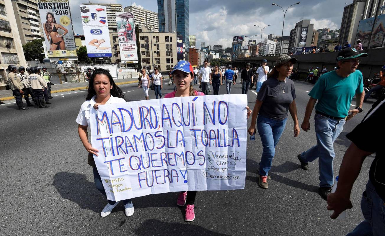 Fue en el medio de esa vía donde los principales líderes de la alianza opositora Mesa de la Unidad Democrática (MUD) ofrecieron discursos en una pequeña tarima desde la que pudieron escuchar a los ciudadanos opositores pedirles que la movilización se trasladara al palacio presidencial de Miraflores. FOTO AFP