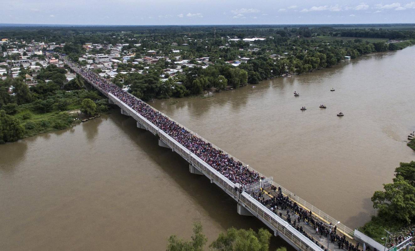 Miles de migrantes hondureños, que salieron en caravana de su país con destino a Estados Unidos, viven una tensa espera en el puente fronterizo entre México y Guatemala. FOTO AFP