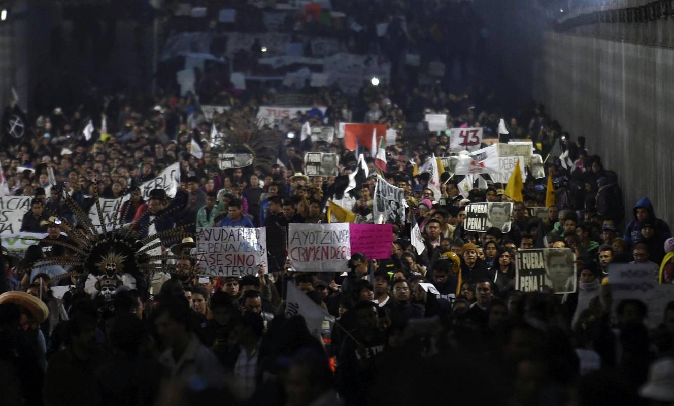 Los manifestantes caminaron hacia el Zócalo, la plaza principal del centro de la capital, mientras alzaban banderas mexicanas pintadas de negro en señal de duelo. FOTO AFP