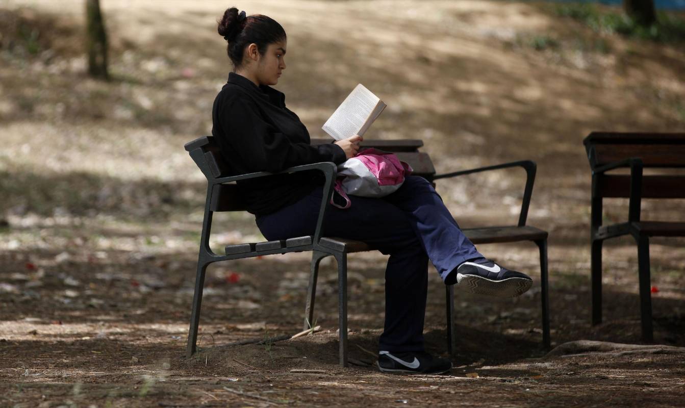 En medio de la agitada rutina de la ciudad, lectores espontáneos aprovechan un momento de calma para leer un buen libro. Foto: Manuel Saldarriaga.