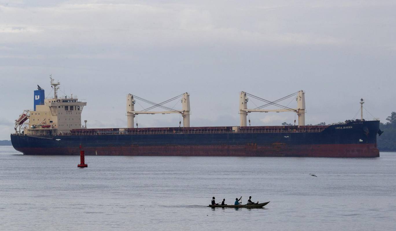 En el puerto de Buenaventura los súper cargueros hacen sus recorridos con los contenedores llenos de mercancía sin dejar de arropar y dar sustento a sus nativos canoeros. Foto: Manuel Saldarriaga Quintero