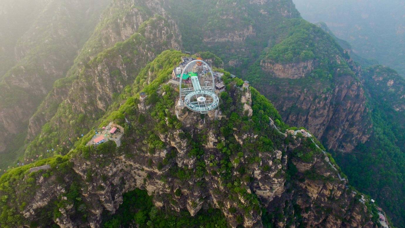En China inauguraron un mirador de cristal de 415 metros cuadrados en un precipicio de 32,8 metros de altura. La atracción ubicada en Shilinxia, en el distrito de Pinggu, en Pekín se puso de moda entre los turistas. FOTO AFP