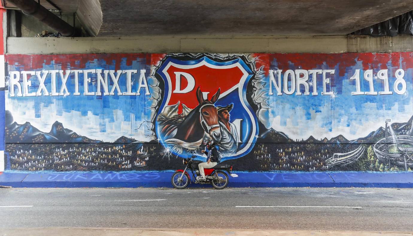 Barristas de Independiente Medellín y Atlético Nacional intervinieron el deprimido de San Juan con la 80, en el barrio La América, y enviaron a la ciudad un mensaje de respeto y convivencia a menos de ocho días de otro clásico paisa. FOTO ROBINSON SÁENZ 