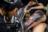 Un tatuador hace su trabajo. Foto: AFP