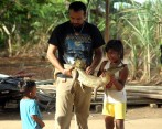 El biólogo Sergio Balaguera-Reyna mientras muestra a unos niños un caimán del Apaporis en la selva del Amazonas, al sur de Colombia. FOTO EFE