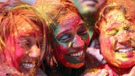 Los jóvenes sonríe embadurnados de colores mientras una multitud celebra, este miércoles, el festival Holi . Foto: EFE/ Divyakant Solanki