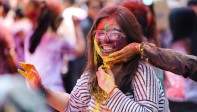 Los jóvenes sonríe embadurnados de colores mientras una multitud celebra, este miércoles, el festival Holi . Foto: EFE/ Divyakant Solanki