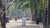 Uno de los sobrevivientes le dio al Papa una fotografía en la que aparecía rodeado por otros prisioneros en un catre y le pidió que la firmara. El Papa besó a cada sobreviviente. FOTO AP