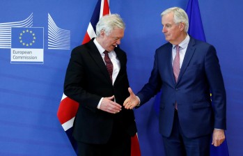 El representante británico para la UE, David Davis, y el negociador de la UE, Michel Barnier, posan tras la reunión en Bruselas que dejó establecidos los nuevos tiempos del Brexit. Foto afp