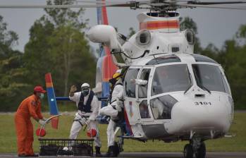 Los miembros de un equipo de búsqueda y rescate de Indonesia descargan el cadáver de un pasajero del vuelo QZ8501 de AirAsia en Pangkalan Bollo, la ciudad con la pista de aterrizaje más cercana al lugar de las operaciones de búsqueda. FOTO AFP