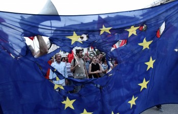 Miles de ciudadanos en Atenas, simpatizantes del partido de gobierno (Syriza), marcharon con banderas rotas de la UE, que advierten sobre la situación que podría seguir tras el default. FOTO ap
