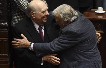 Julio Sanguinetti y José Mujica, saltándose los protocolos de bioseguridad, se dieron un abrazo al momento de anunciar su renuncia. FOTO AFP