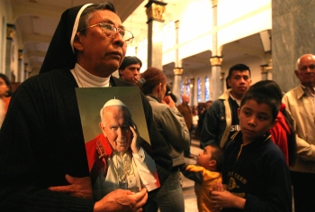 Colprensa - Una religiosa rindió homenaje a Juan Pablo II en la Basílica del 20 de Julio durante la misa ofrecida en su memoria.