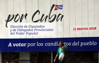 Una mujer camina frente a un cartel alusivo a las elecciones generales, en La Habana (Cuba). FOTO EFE