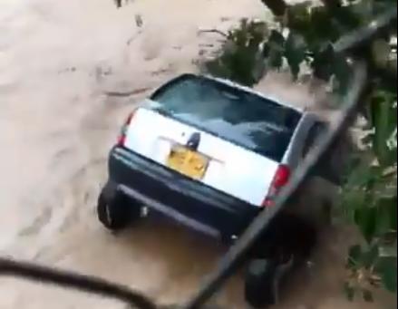 Un automóvil, sin ocupantes, fue arrastrado por la corriente de agua que afectó la vía central de Santa Elena por el desbordamiento de la quebrada. FOTO CAPTURA DE VIDEO