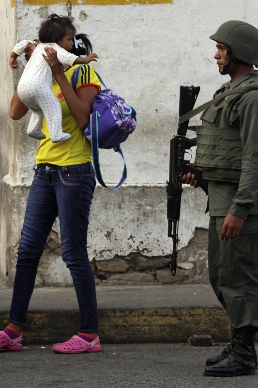 Bajo la mirada vigilante de la Guardia venezolana una colombiana transita en el sector cerrado de San Antonio, Táchira. FOTO REUTERS.