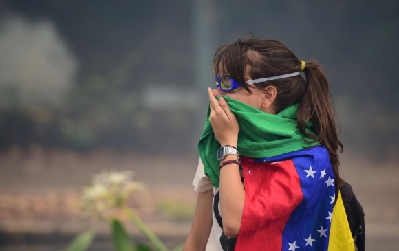 Imagen de archivo de una estudiante de la Universidad Central de Venezuela durante protestas en contra del gobierno el pasado mes de mayo. Los universitarios son víctimas de represión. FOTO AFP