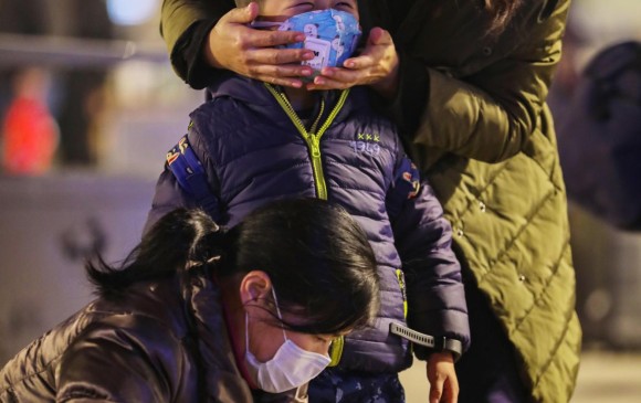 Wuhan: esta es la ciudad origen del virus. Una madre le revisa la máscara a su pequeño hijo a las afueras de la estación de trenes de Hankou. Foto: Efe