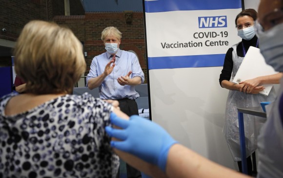 El primer ministro británico, Boris Johnson, aplaude después de que una enfermera administra la vacuna Pfizer-BioNTech. FOTO AFP