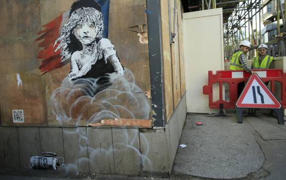 El mural del misterioso grafitero muestra a la niña pequeña que aparece en el musical “Los Miserables” con lágrimas en sus ojos, mientras que, de fondo, se ve una lata del gas. FOTO AP