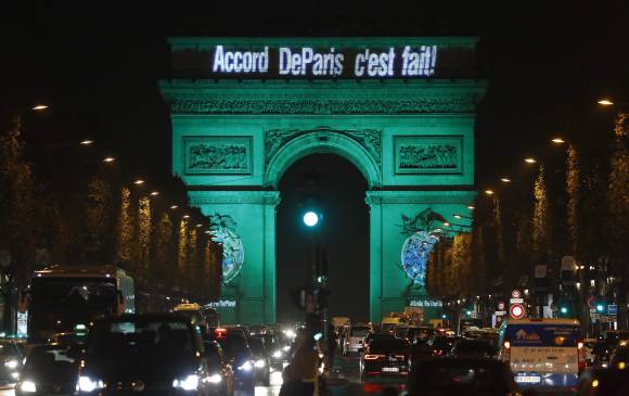 El Arco del Triunfo y otros monumentos de París se iluminaron por la entrada en vigencia de acueros de COP21. FOTO AFP