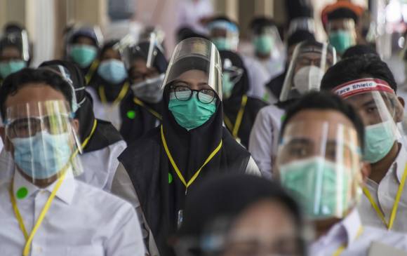 Uso de elementos de protección como medida de precaución contra la propagación del coronavirus en Indonesia. FOTO AFP