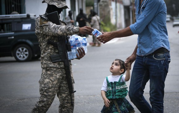 En Gaza integrantes de la Jihad Islámica Palestina aprovechan para repartir agua a la población. FOTO AFP