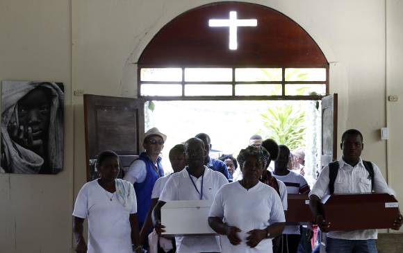 Un grupo de familiares ingresa a la antigua iglesia de Bojayá, lugar donde ocurrió la masacre en 2002, con los restos de las víctimas de la masacre de Bojayá. FOTO EFE