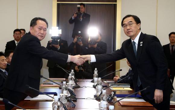 Ri Son-gwon delegado de Corea del Norte, estrecha la mano de Cho Myoung-gyon, quien representó al gbierno de Corea del Sur, tras los acuerdos logrados para participar en los Juegos. FOTO EFE