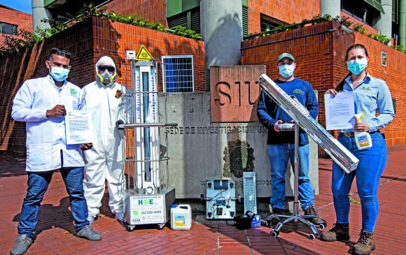 Juan David (primero) con sus compañeros y el robot que funciona con luz solar e inactiva al Sar-Cov-2 que hay en el país. FOTO Jaime Pérez