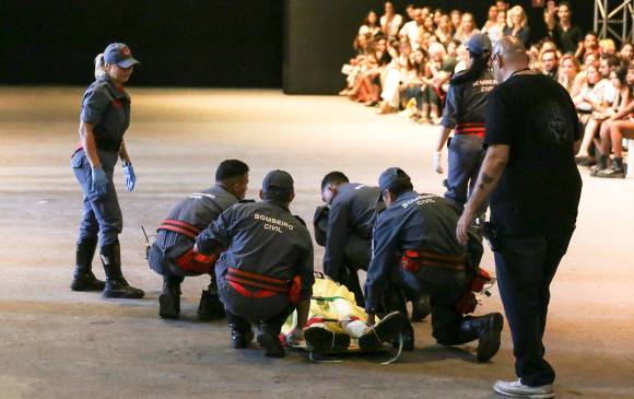 Bomberos auxilian al modelo Tales Cotta este sábado durante un desfile de la Semana de la Moda en Sao Paulo (Brasil). FOTO: EFE