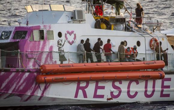 Migrantes se paran en el barco de rescate financiado por el artista callejero británico Banksy “Louise Michel” durante una operación de rescate de miembros de la tripulación del barco de rescate marítimo Sea-Watch 4, frente a la costa de Malta, el 29 de agosto deL 2020. FOTO AFP