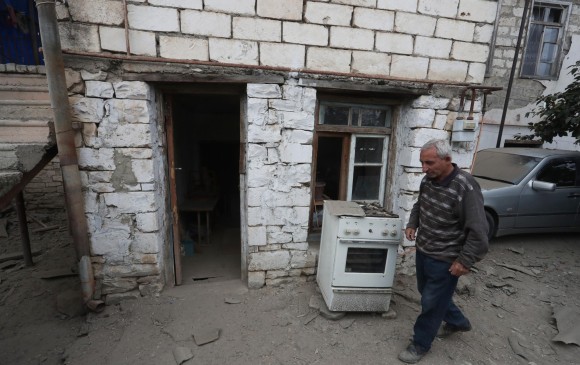 Un hombre camina frente a una casa dañada por el ataque de las fuerzas azeríes en la región separatista de la ciudad de Martuni, en Nagorno Karabaj. FOTO AFP