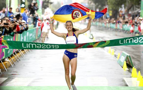 Sandra Arenas mostró su gran felicidad exhibiendo la bandera colombiana antes de pasar la meta. FOTO cortesía coc 