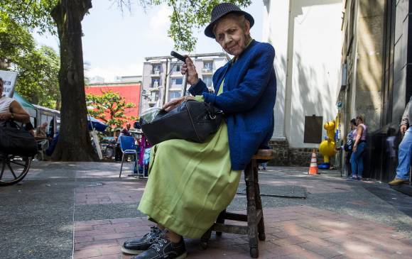 Ángela María Vélez, conocida como “la Gatica”, se ubica junto al edificio La Bolsa, en el Parque Berrío. FOTO Julio César Herrera