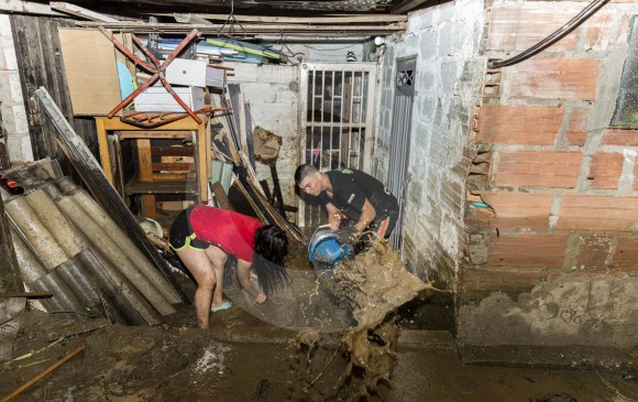 Habitantes de La Iguaná pasaron la noche sacando agua y limpiando sus viviendas. La solidaridad entre todos los vecinos fue clave para retirar el lodo cuanto antes. FOTO CAMILO SUÁREZ