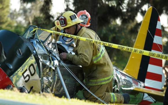 Personal de rescate quita la avioneta accidentada en el campo de golf. FOTO AFP