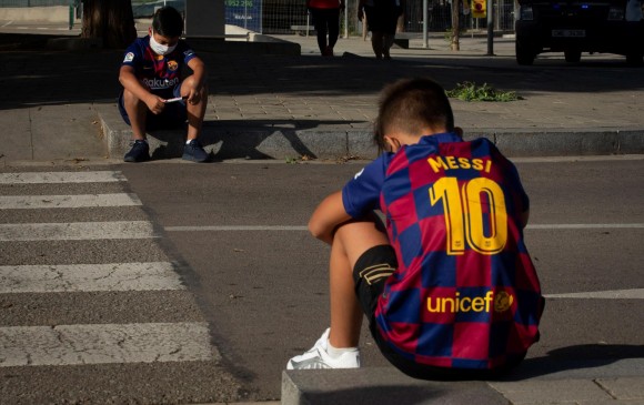Infructuosa espera al frente de la concentración del Barcelona. Estos dos jóvenes aficionados lloran la ida de Messi. FOTO EFE